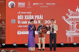 VNA General Director Vu Viet Trang (left) and Vice Chairman of the Hanoi People’s Committee Ha Minh Hai (right) presents the Grand Prize of the “Bui Xuan Phai: For the Love of Hanoi” Awards to architect Hoang Dao Kinh at the ceremony on October 8. (Photo: VNA)
