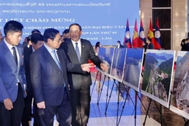 PMs of Vietnam, Laos visit photo exhibition on achievements of economic ties