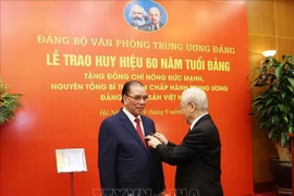 60-year Party membership badge presented to former Party chief Nong Duc Manh