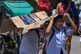 Students use a cardboard to protect themselves from the sun during a hot day in Manila on April 2, 2024. (Photo: philstar.com) 