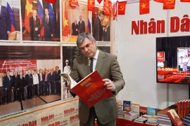 Vyacheslav Kalganov, Vice Chairman of the Committee for External Relations of Saint Petersburg visits the stall of Nhan Dan (People) in Saint Petersburg Int’l Book Fair (Photo: VNA)