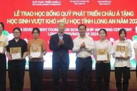 Nguyen Van Duoc, Secretary of the provincial Party Committee and Chairman of the Long An People's Council; Kim Joon Il, Chairman of COBI Group and ADF; and students at the ceremony. (Photo: VNA)
