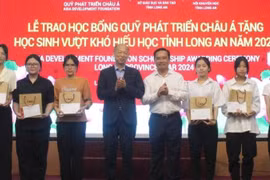 Nguyen Van Duoc, Secretary of the provincial Party Committee and Chairman of the Long An People's Council; Kim Joon Il, Chairman of COBI Group and ADF; and students at the ceremony. (Photo: VNA)