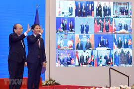Vietnamese Prime Minister Nguyen Xuan Phuc (left) and Minister of Industry and Trade Tran Tuan Anh, together with leaders of other RCEP member countries, witness the pact signing via videoconference on November 15 (Photo: VNA)