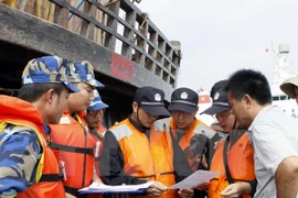 Vietnamese and Chinese marine police checked fishing licences of Chinese fishermen (Photo: VNA) 
