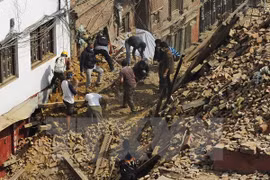 People search for victims under rubble caused by the quake (Photo: AFP/VNA)
