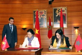 Nguyen Phuong Nga and Mbarka Bouiada sign a meeting minute (Photo: VNA)