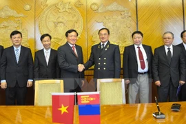 Procurator General Nguyen Hoa Binh (L) and Mongolian General Prosecutor M. Enkh-Amgalan. (Photo: VNA)