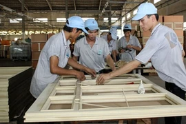 Employees produce wooden wardrobes at the Kaiser Wood Company in Binh Duong (Photo: VNA)