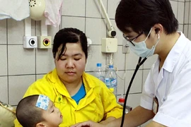 A doctor examines a child at the Paediatrics Ward of Bach Mai General Hospital in Hanoi (Photo: VNA)