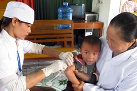 A child was given vaccine shot in Vietnam. (Photo: VNA)