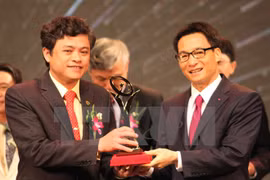 Deputy Prime Minister Vu Duc Dam (right) grants the 2014 National Quality Awards to businesses (Photo: VNA)