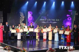 Teachers receive certificates of merit at the event (Photo: VNA)