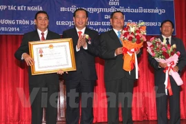 On behalf of Vietnamese President Truong Tan Sang, Chairman Nguyen Manh Hien (second from left) presents Vietnam's Independence Order (second class) to Vientiane authorities and people (Photo: VNA)