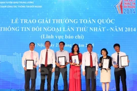 Politburo members Le Hong Anh (third, right) and Dinh The Huynh (second, left) and first prize winners (Photo: VNA)