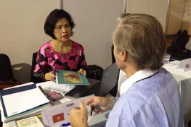 A representative of the Vietnam Trade Office in Argentina provides information for a visitor to the Fiar 2015 (Photo: VNA)
