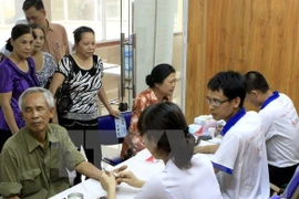 Medical workers give check-ups and advice to patients (Photo: VNA)