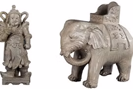 A white glazed elephant (right) fromthe Nguyen dynasty in the 19th century and a glazed statue of the pagoda guardian that dates back to the 17th century.