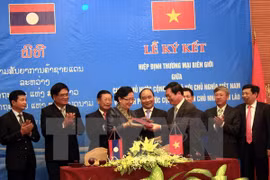 inister of Industry and Trade Vu Huy Hoang (R) and his Lao counterpart Khemmani Pholsena sign the agreement (Photo: VNA)