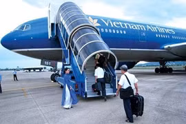 Passengers board a Vietnam Airlines plane. The carrier is speeding up divestment of non-core businesses. Photo: vietnamdomesticflights.com