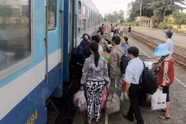 Passengers get on a train (Photo: VNA)
