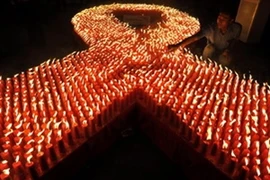 Burning candles to commemorate the World AIDS Day (Source: VNA)