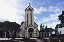 Tourists sit in front of a church in Sapa resort town (Photo: VNA)