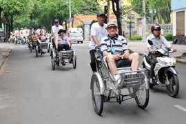 Foreigners sit on cyclos to tour Ho Chi Minh City (Photo: VNA)