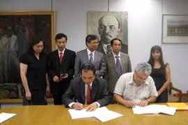 Representatives of the Communist Review and SolidNet sign a MOU (Source: VNA)