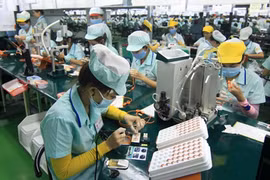 Staff at Foster Electronics Company in Quang Ngai province work on a headphone production line (Photo: VNA)