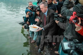 US Ambassador Ted Osius releases carp into West Lake as part of an ancient Vietnamese festival to honour the Kitchen God. (Photo: VNA)