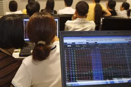 Investors watch market movements at a securities trading floor in Ha Noi. (Photo: VNA)