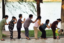 Senior citizens do morning exercises at the Hoan Kiem (Sword) Lake in Hanoi (Photo: VNA)