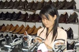 A customer examines leather shoes made by the Vina Shoes Corporation at a store in HCM City. Vietnam has become the largest footwear exporter to Brazil with a turnover of 335.66 million USD last year. (Photo: VNA)