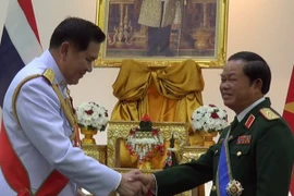 Commander of the Royal Thai Armed Forces Tanasak Patimapragorn presented the order to Deputy Defence Minister Senior Lieutenant General Do Ba Ty (R). Photo: VNA