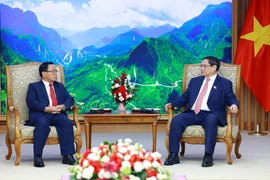 Prime Minister Pham Minh Chinh (R) receives visiting President of the Lao State Inspection Authority Khamphan Phommathat at their meeting in Hanoi on June 3. (Photo; VNA)