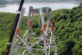 Workers persevere through sun and rain to complete transmission line