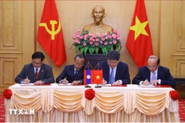 Representatives from the Ho Chi Minh National Academy of Politics, the Vietnam Academy of Social Sciences, the Lao National Academy of Politics and Public Administration, and the Lao National Institute of Economic and Social Sciences sign cooperation agreements on June 30, 2023. (Photo: VNA)