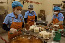 Workers make "cu do" - a candy made of roasted peanuts and molasses and covered with rice pancakes. The candy is a three-starred OCOP product of the central province of Ha Tinh. (Photo: VNA)
