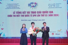 Nguyen Do Quang Minh (centre), a 9th grader in the central city of Da Nang, recieves the first prize at the awarding ceremony in Ninh Binh province. (Photo: VNA)