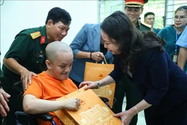 Vice President Vo Thi Anh Xuan gives a gift to an AO victims at the centre for caring, nurturing and treating victims of AO/dioxin in Ba Vi district, Hanoi. (Photo: VNA)