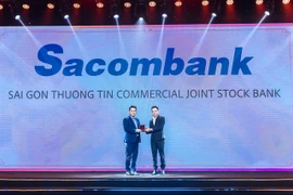 Nguyen Viet Trung, deputy director in charge of the Sacombank Human Resource Management Centre, receives the “Best Company to Work for in Asia” award given to the bank by HR Asia magazine. (Photo: Courtesy of Sacombank)