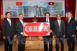 Ambassador Nguyen Manh Hung (second, left) presents 40 billion VND for building a cultural centre in Luang Prabang (Photo: VNA)