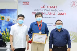 Writer Binh Ca (centre) receives a Cricket Desire award. (Photo: VNA)
