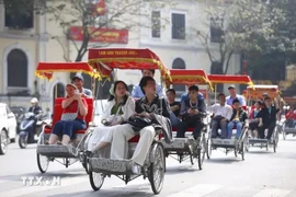 Visitors in a cyclo tour around Hoan Kiem Lake in Hanoi (Photo: VNA)