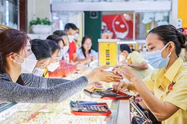 Customers purchase gold rings at a jewellery store. (Photo: cand.com.vn)