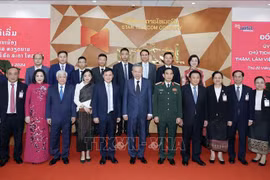 President To Lam (middle, first row) takes a group photo with representatives of Star Telecom (Unitel) as part of his state visit to Laos on July 11. (Photo: VNA)