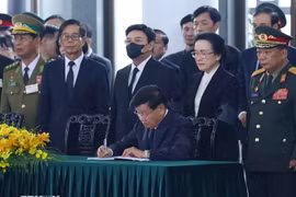 Party General Secretary and President of Laos Thongloun Sisoulith writes in the condolence book (Photo: VNA)