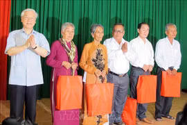 Party General Secretary Nguyen Phu Trong (first, left) gives presents to policy beneficiary families in the southern province of Soc Trang during his visit to My Xuyen district in 2015. (Photo: VNA)