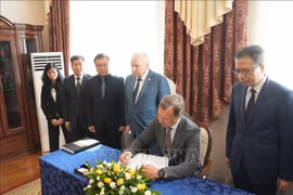 First Deputy Speaker of the Federation Council of the Federal Assembly of Russia Aleksey Yatskin writes in condolence book (Photo: VNA)